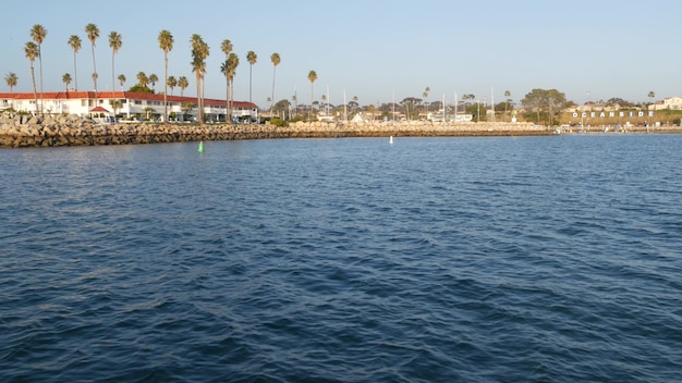 Sailing boat or yacht, Oceanside harbor in California USA. City sign in port marina, ocean coast.