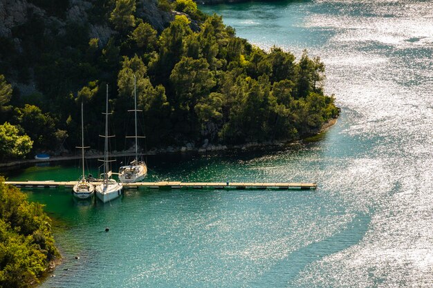 Photo sailing boats anchored in the krka river estuary in the close proximity of the town of skradin