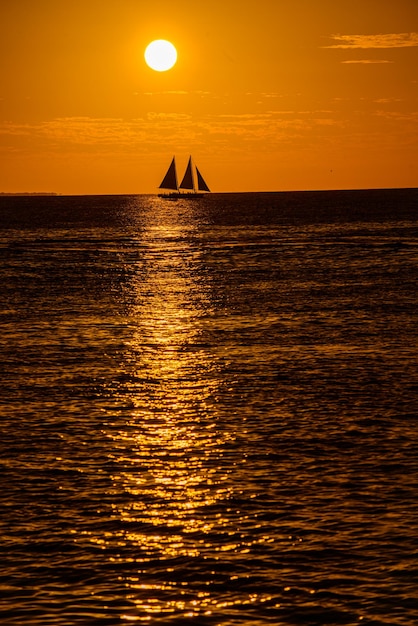 美しい夕日を背景にした帆船