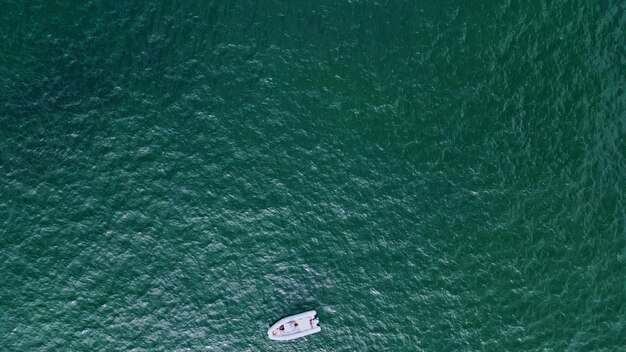 Фото Парусный катамаран, плавающий на поверхности воды, вид с вершины, роскошная парусная лодка, плавающая по морю.