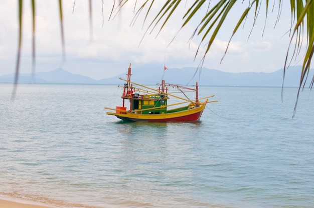 Парусная красочная рыбацкая лодка в морской воде, разноцветная лодка в мелководном тропическом океане. Таиланд