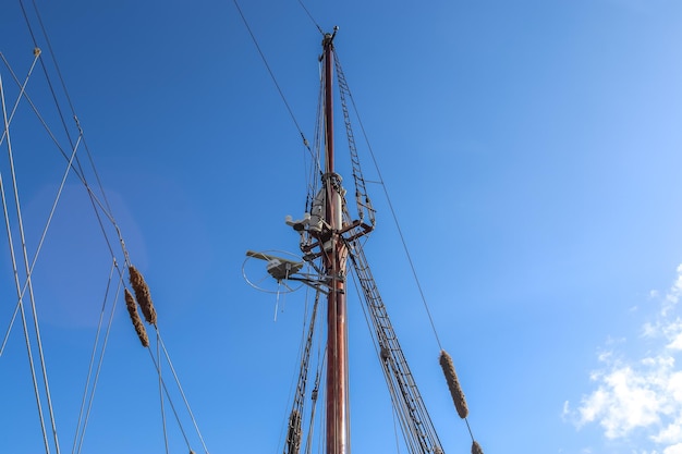 Photo sailing ship mast against the blue sky on some sailing boats with rigging details