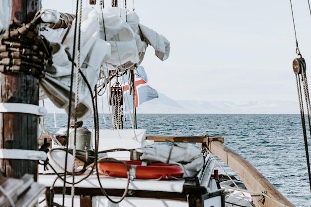 Парусное судно движется по морю по горам напротив неба