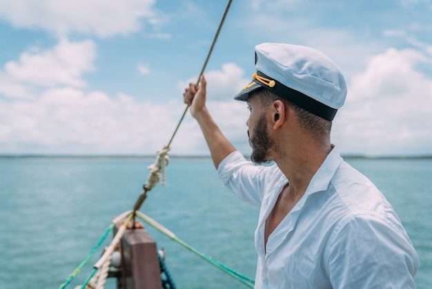 Sailing sport. Captain in charge. Latin american man with ship captain's hat