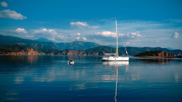 Парусная яхта стоит на якоре в морской бухте.