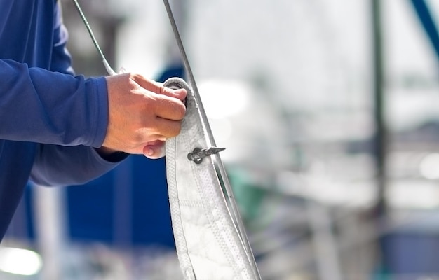 Photo a sailor puts on sails on a yacht for a sea trip preparing the ship for the cruise
