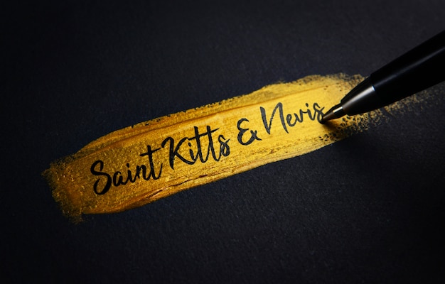 Saint Kitts and Nevis Handwriting Text on Golden Paint Brush Stroke