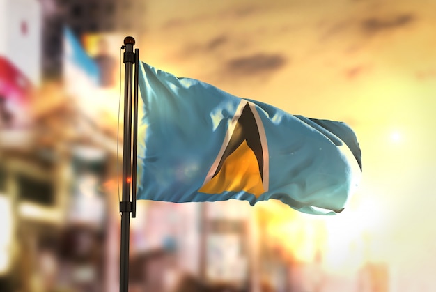 Saint Lucia Flag Against City Blurred Background At Sunrise Backlight