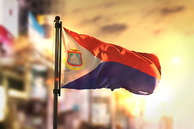 Saint Martin Flag Against City Blurred Background At Sunrise Backlight