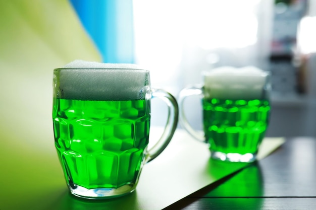 Saint patrick\'s day holiday. national irish holiday. green\
beer. hand with a mug of emerald beer in a bar.