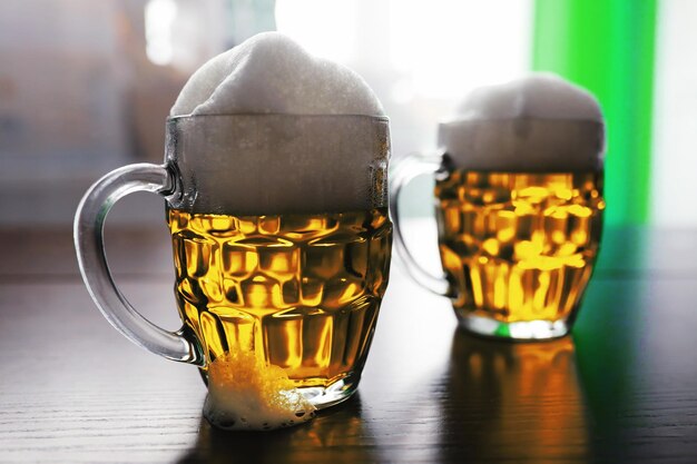 Foto festa di san patrizio. festa nazionale irlandese. birra verde. mano con una tazza di birra color smeraldo in un bar.