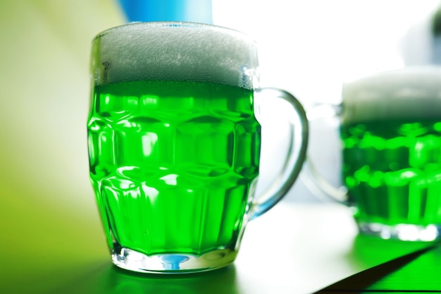 Saint patrick\'s day holiday national irish holiday green beer\
hand with a mug of emerald beer in a bar