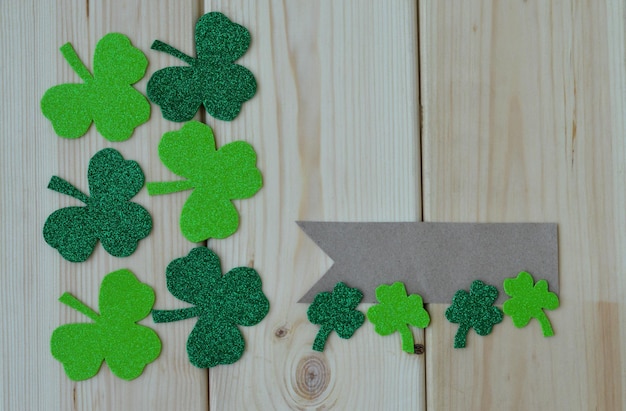 Saint Patricks Day background with green shamrock on a wooden background top view with a label for the inscription a place for the text