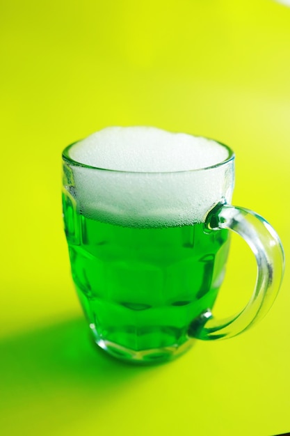 Saint patricks day holiday national irish holiday green beer\
hand with a mug of emerald beer in a bar