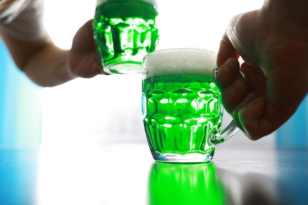 Saint Patricks Day holiday National Irish holiday Green beer Hand with a mug of emerald beer in a bar