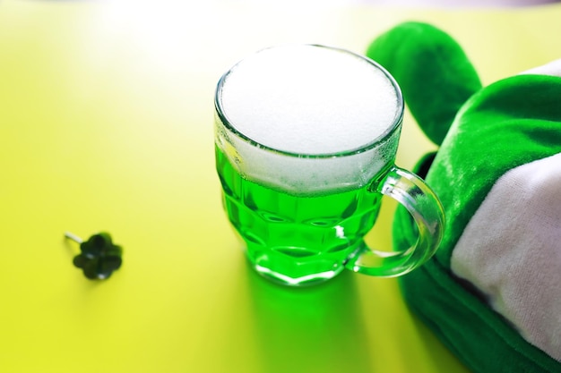 Saint patricks day holiday national irish holiday green beer\
hand with a mug of emerald beer in a bar