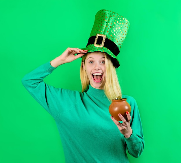 Saint patricks day leprechaun holds pot with gold smiling girl in leprechaun costume holds pot with