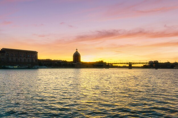 Photo saint-pierre bridge reflecting in garonne river and dome de la grave in toulouse