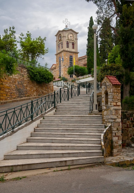 Saints Anargyri Holy Orthodox Church with a clock and a cross on the island of Evia in Greece