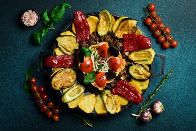 Saj traditional Azerbaijani food Lamb saj in a metal pan Free space for text On a dark background