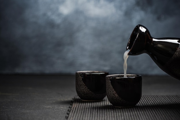Foto sake gieten in een nippende keramische kom