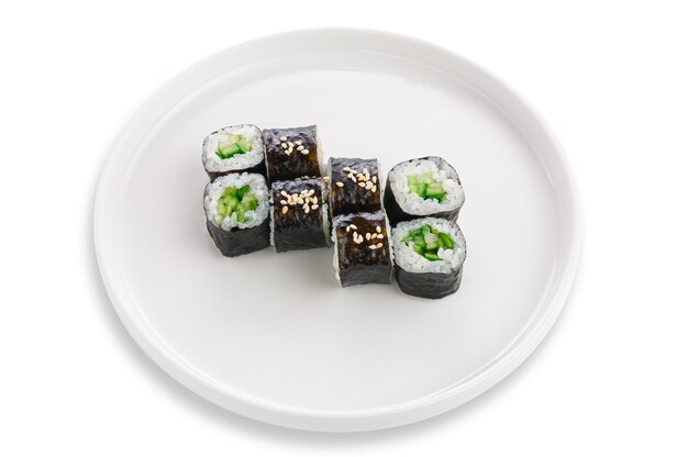 Rotolo di sake maki con cetriolo e sesamo. vegetariano. su un piatto di ceramica bianca. sfondo bianco. isolato.