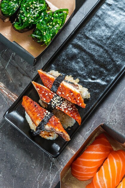 Sake sushi unagi sushi op een serveerschaal sushi op een donkere achtergrond Japans eten