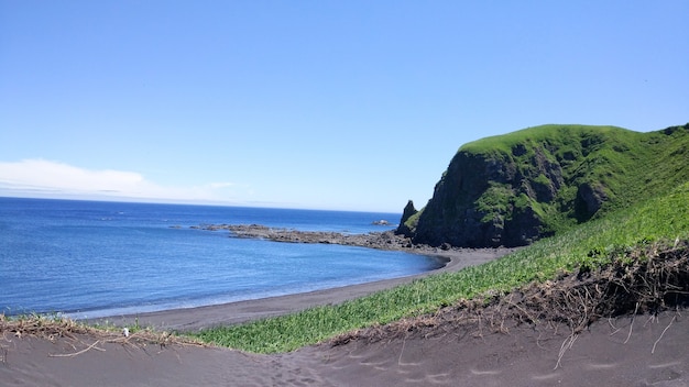 サハリン島崖海は海のビーチと緑の丘を眺める