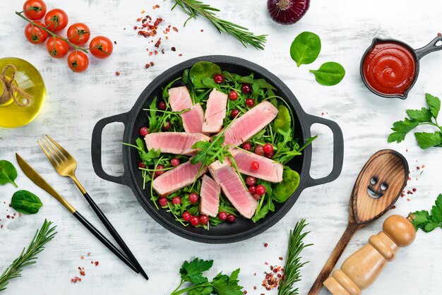 Salad arugula tuna and avocado on a black stone plate Top view Free space for text