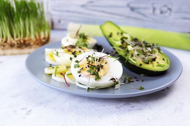 Salad of avocado boiled eggs leek mustard microgreens and wheat germ