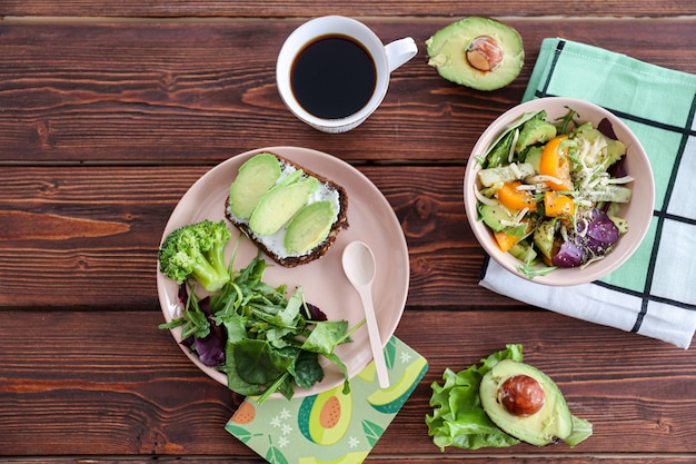 Insalata di avocado e panino al caffè su uno sfondo di legno