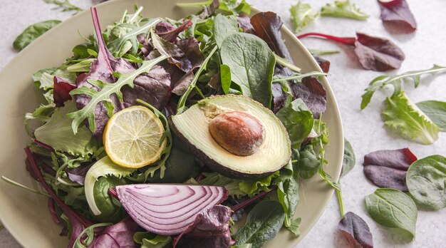 Salad of avocado and vegetables mixed greens lettuce leaves ready to eat