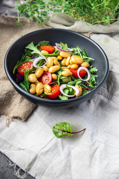 サラダ豆トマトタマネギレタスの葉はテーブルコピースペースに新鮮な健康的な食事ダイエットスナックを混ぜます