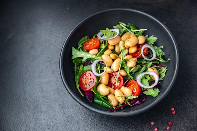 salad bean tomato onion lettuce leaves mix fresh healthy meal diet snack on the table copy space