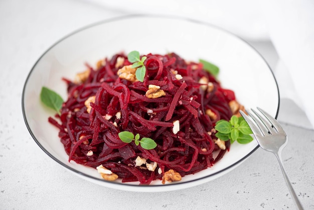 Salad of boiled beets and walnuts in a white bowl