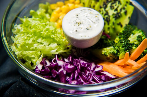 Salad bowl. Ingredients broccoli, corn, carrots, couscous, lettuce, cabbage, sauce.