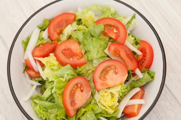 Salad bowl on a white wooden background