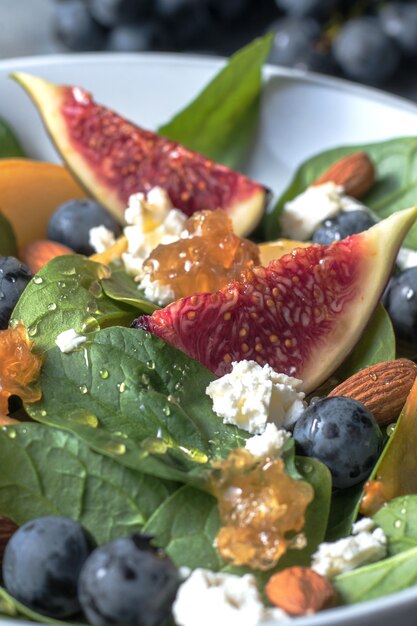 salad bowl with spinach figs pears grapes cottage cheese and honey