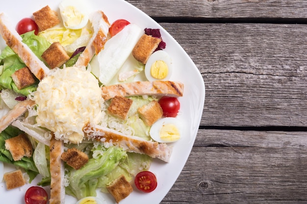 Salad ceasar with chicken eggs tomatoes and croutons