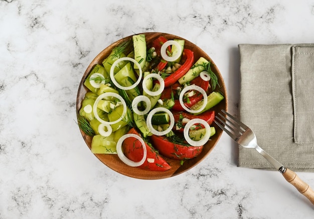 Salad consisting of fermented vegetables tomatoes cucumbers and bell peppers in a wooden plate