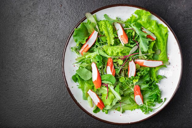 Salad crab stick green lettuce leaves mix petals fresh portion\
meal snack on the table copy space