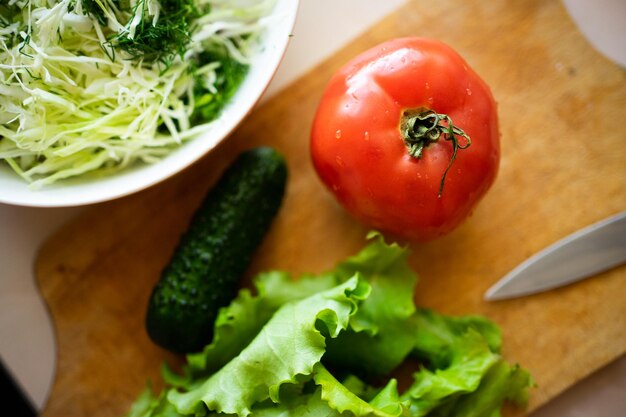 写真 木の板にサラダキュウリポジモアと野菜、健康的なライフスタイルのための新鮮な農産物