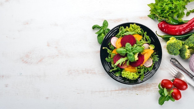 Салат из свежей свеклы, помидоров и салата Здоровая пища На белом деревянном столе Вид сверху Свободное место для текста