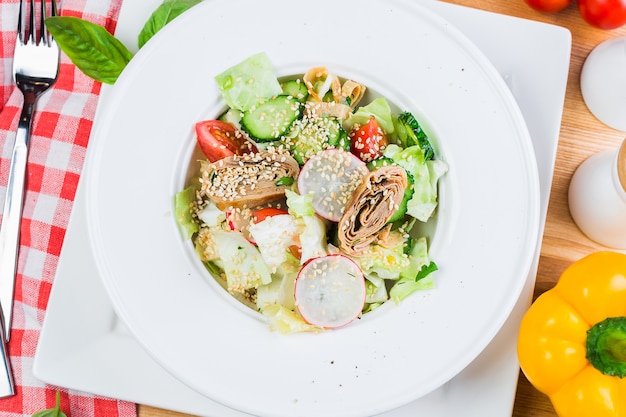 Salad of fresh vegetables with fried pancake roll