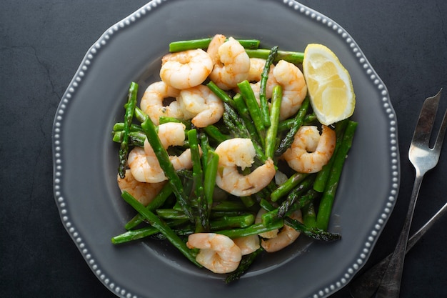 Salad from shrimp and green asparagus. Healthy seafood salad in plate. Top view.