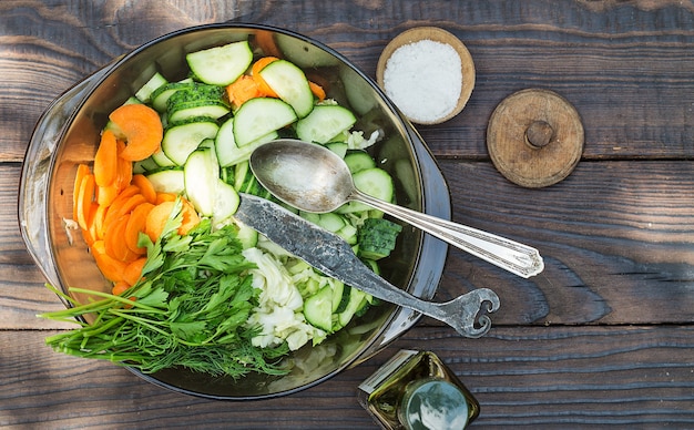 Salad from sliced raw vegetables on the wooden table