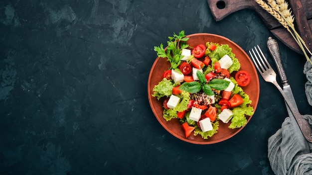Фото Салат в тарелке сыр фета помидоры черри салат паприка здоровая пища на каменном столе вид сверху свободное место для текста