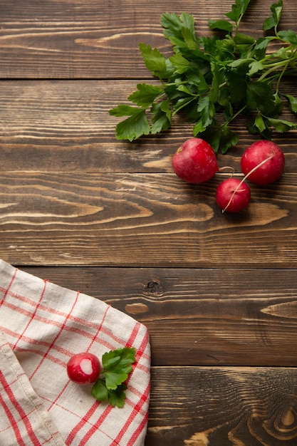 Salad ingredients Red radish lies on the table with a kitchen towel and parsley top view