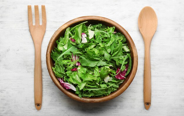 Photo salad mix in a bowl on wooden table