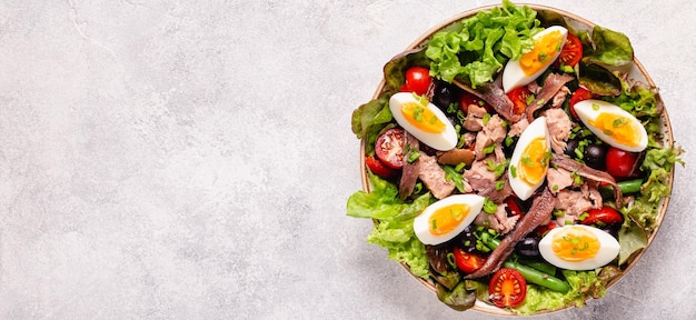 Salad Nicoise with tuna eggs green beans tomatoes olives lettuce and anchovies